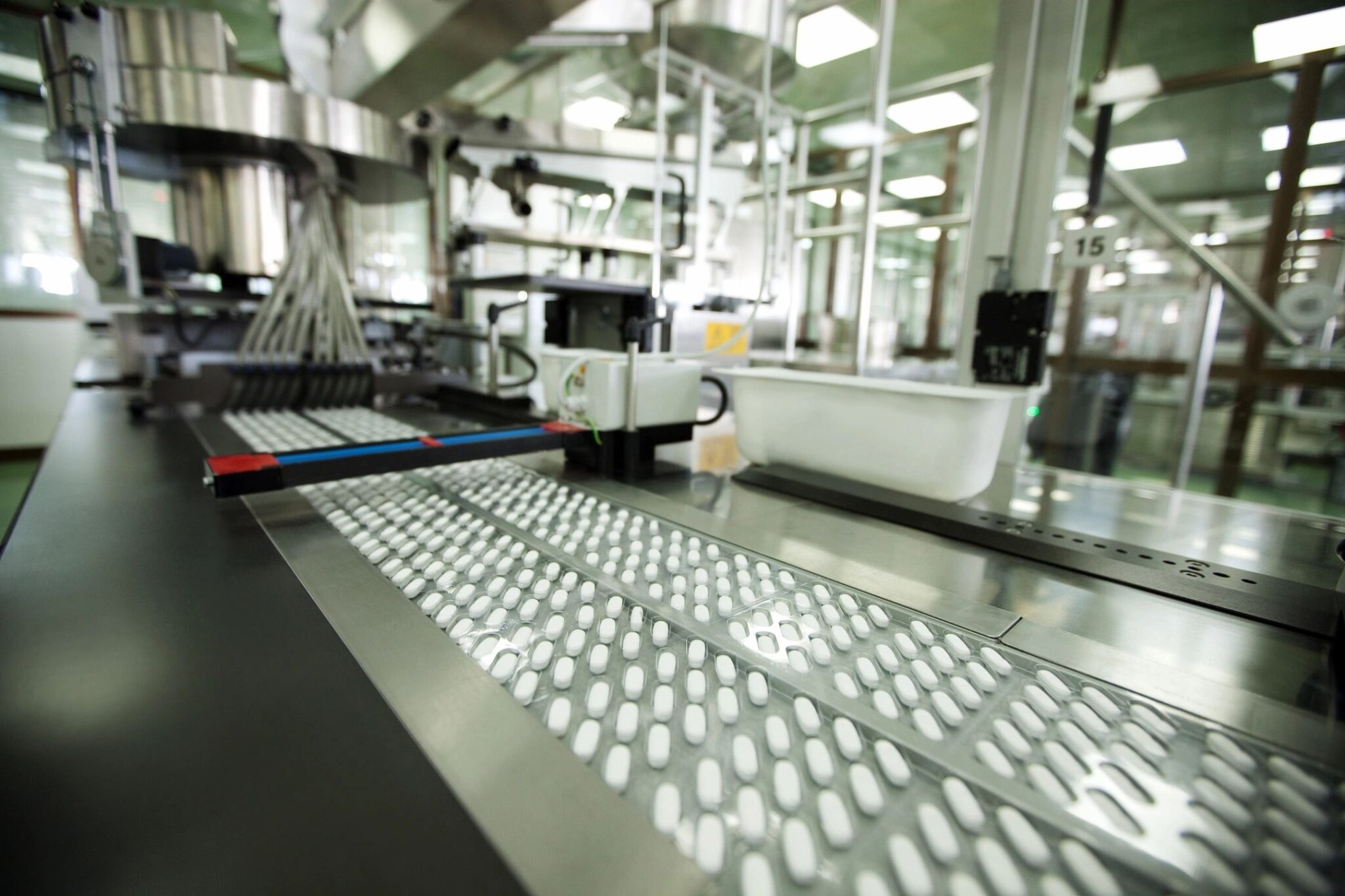 A factory with many machines and lights on the ceiling
