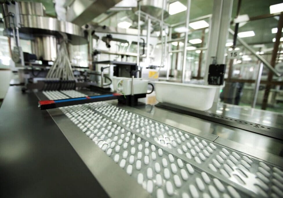 A factory with many machines and lights on the ceiling
